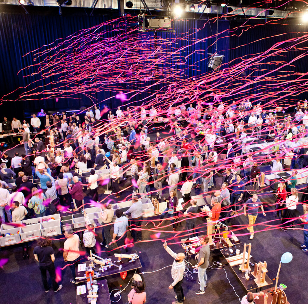 Konfetti fliegt über begeisterte Menschen bei einem Teamevent